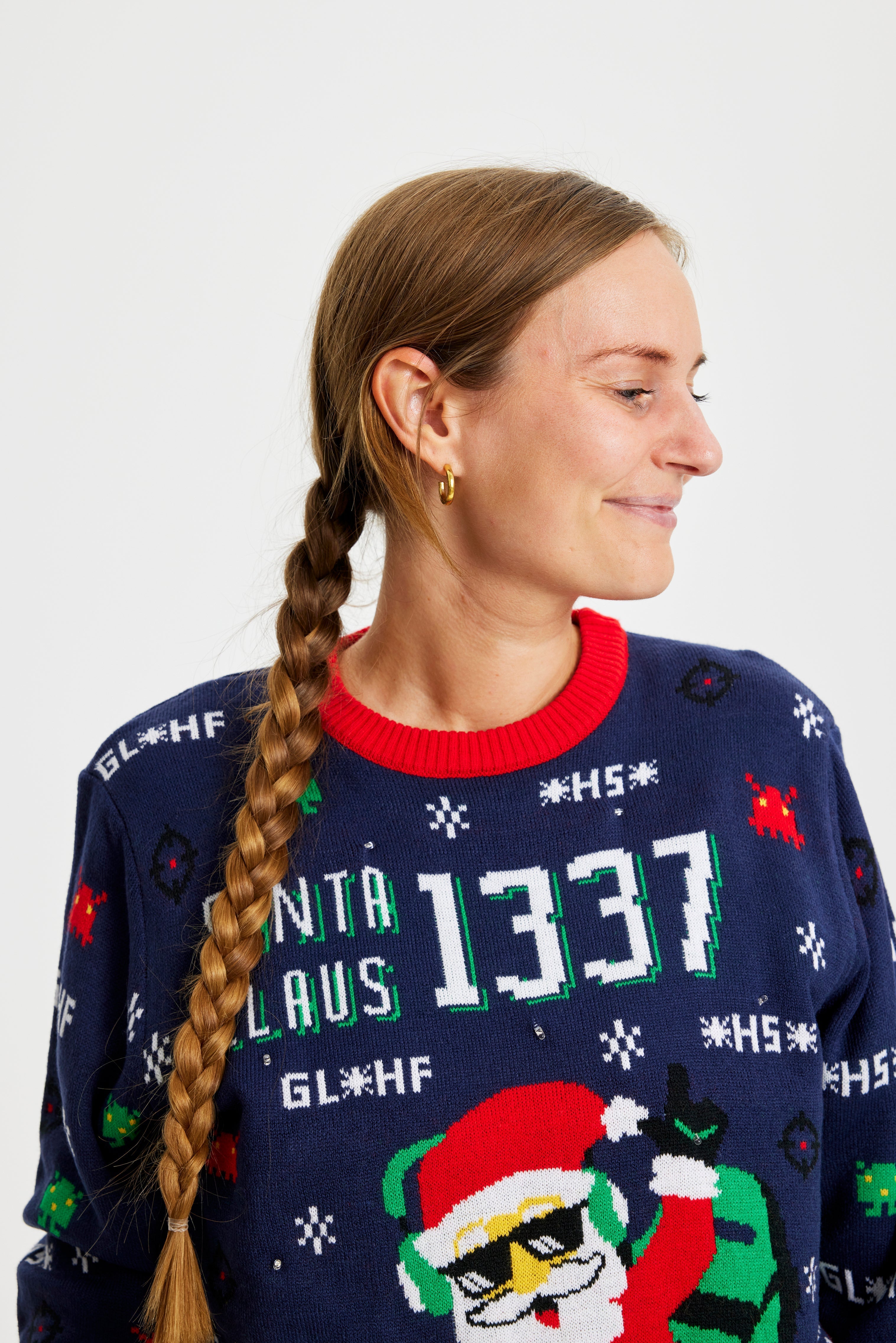 Eine Frau schaut zur Seite und trägt einen Weihnachtspulli mit dem Spruch